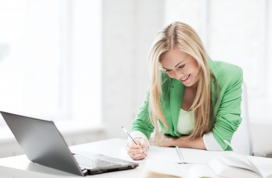 education concept - picture of smiling student girl writing in notebook