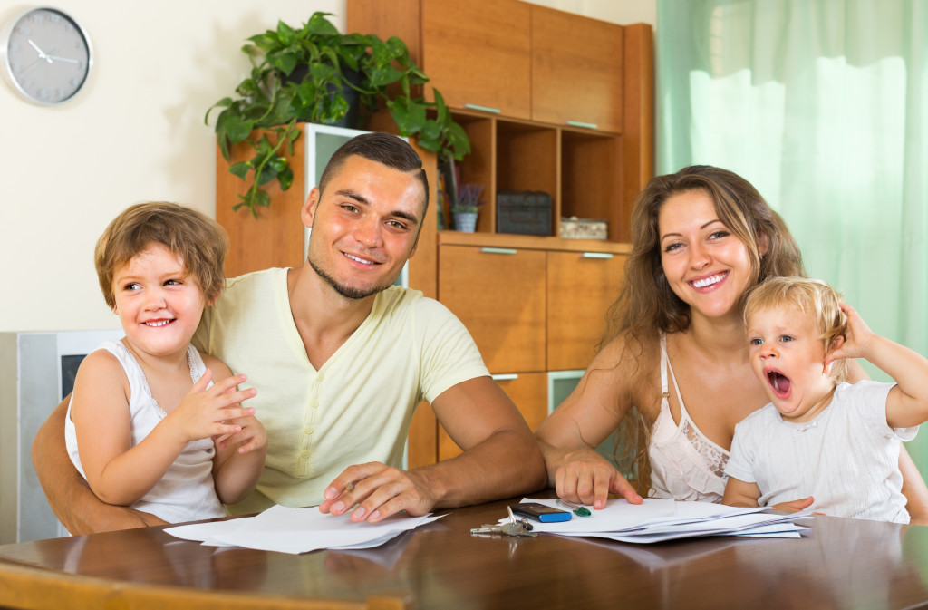 man and woman sitting happy with children signing documents