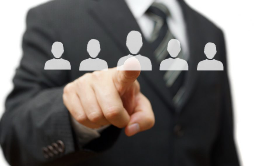 A businessman touching a virtual screen with people icons