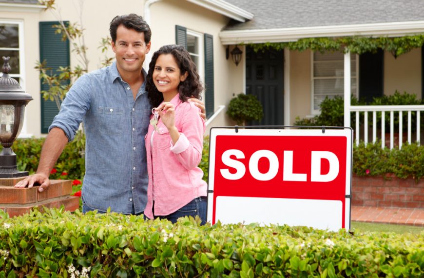 A couple outside a SOLD home